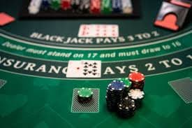 Dealer kasino langsung sedang membagikan kartu dalam permainan blackjack di platform e100